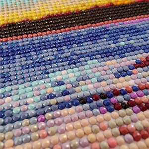 Close-up of a Halloween clown diamond painting kit with colorful round drills arranged in rows.