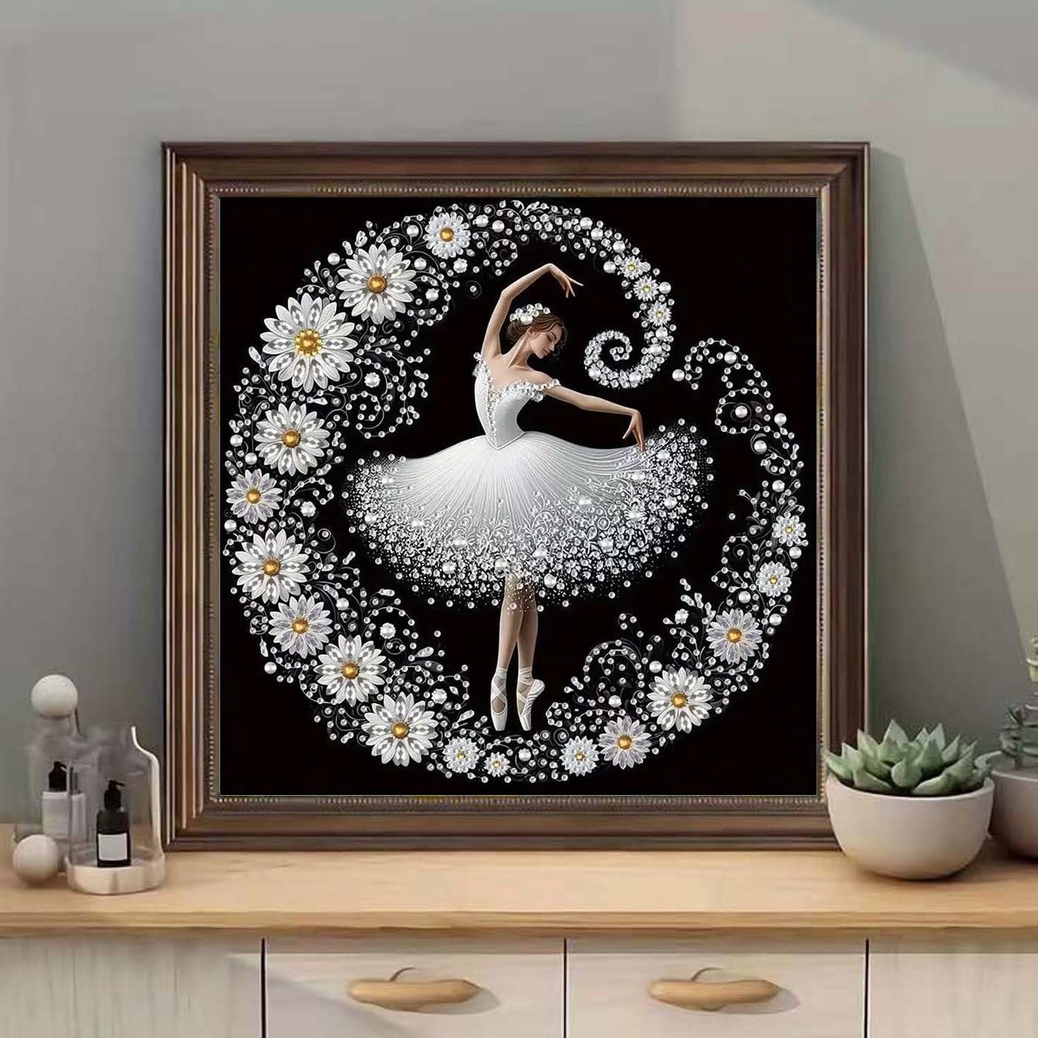 Diamond painting kit featuring a ballerina surrounded by flowers and crystals on a black background, framed.