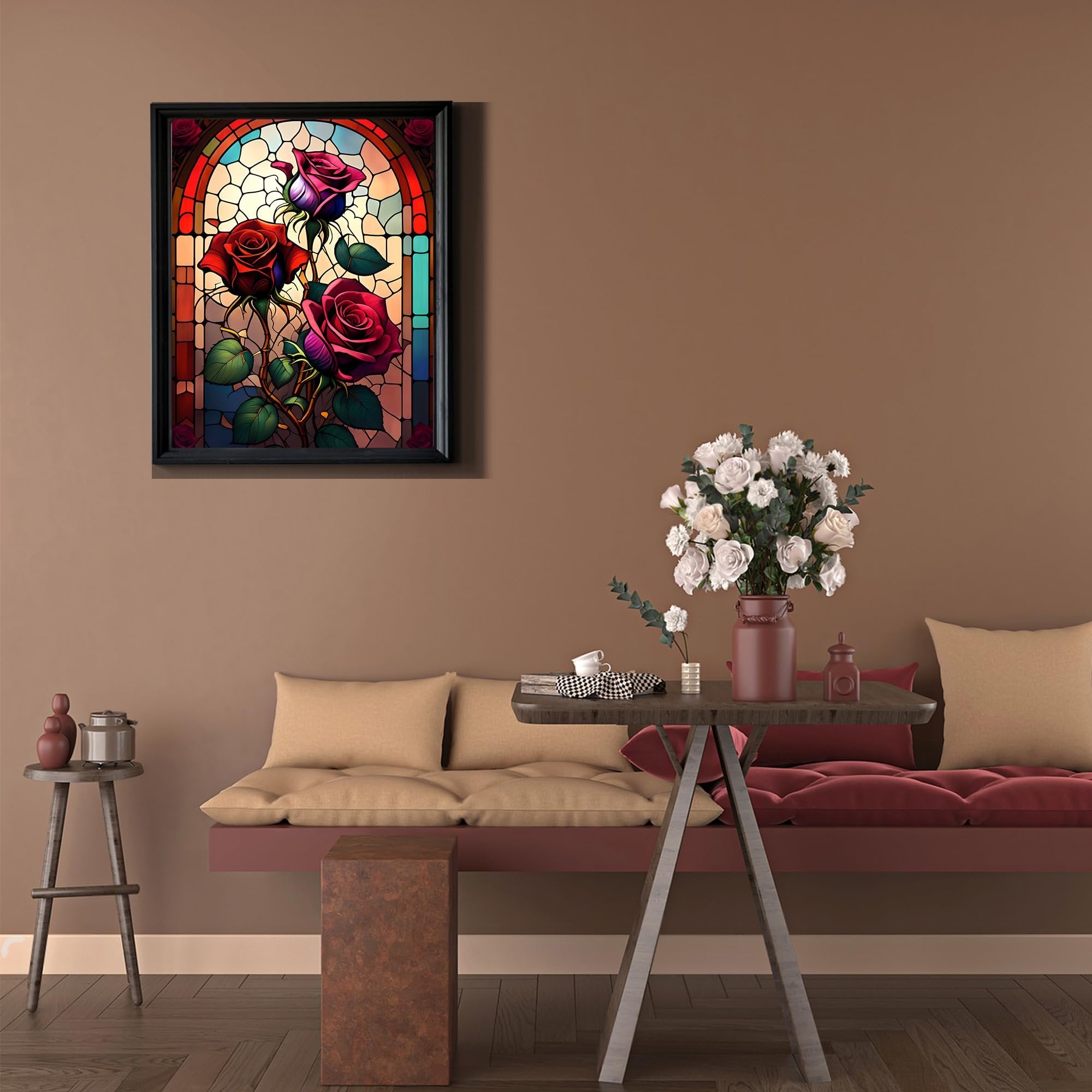 Framed stained glass art of red roses hanging on a wall above a sofa with decorative pillows and a vase of flowers on a table.