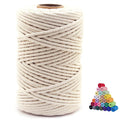 Spool of beige cotton macrame cord with a stack of colorful small spools in the background