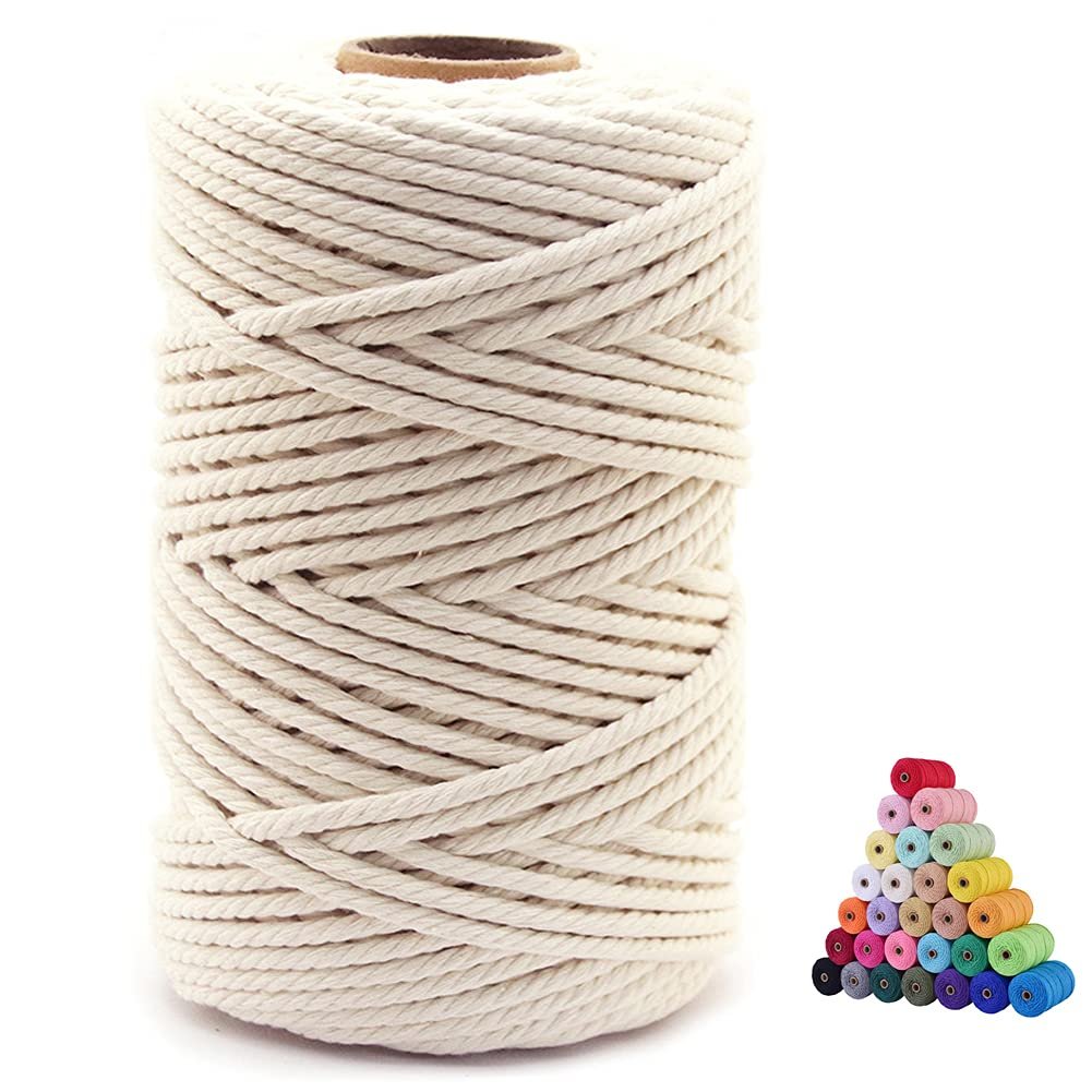 Spool of beige cotton macrame cord with a stack of colorful small spools in the background