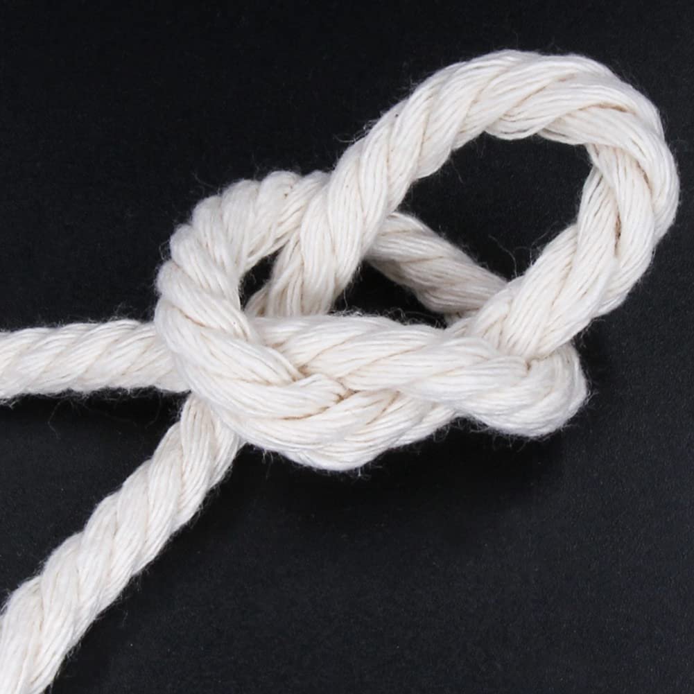 Close-up of a knot tied in beige cotton macrame cord against a black background.