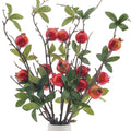 Artificial pomegranate branches with red fruits and green silk leaves in a white vase