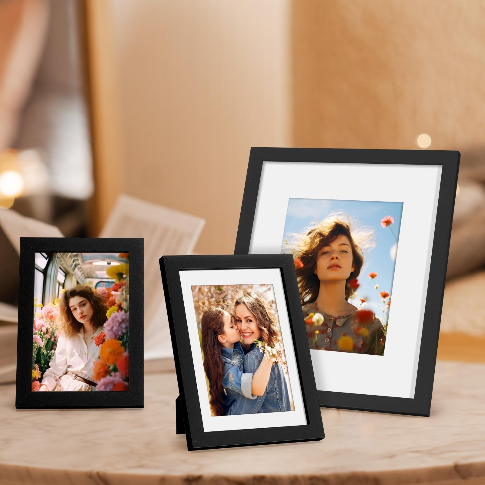 Three black picture frames displaying photos of people and flowers, arranged on a marble surface.