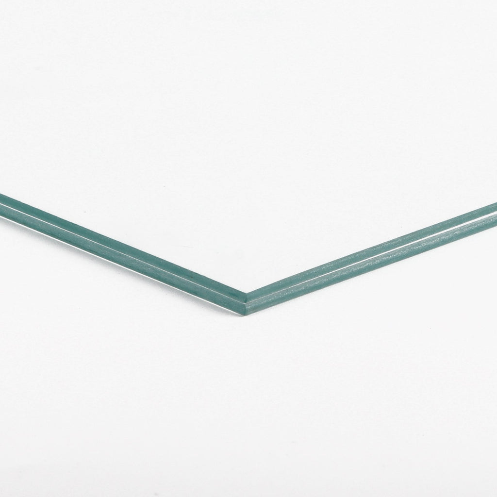 Close-up of two stacked clear glass panes with teal-tinted edges on a white background.
