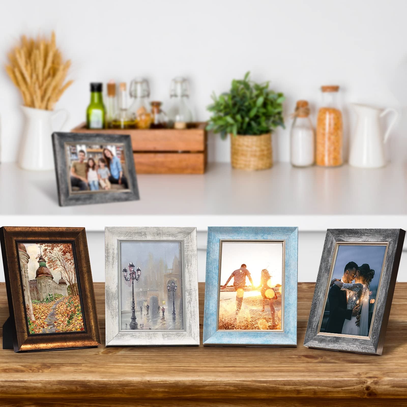 Set of four rustic photo frames displaying different scenes, arranged on a wooden surface with a blurred kitchen background.