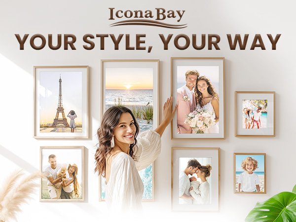 Woman arranging framed photos on a wall, showcasing family and travel memories.