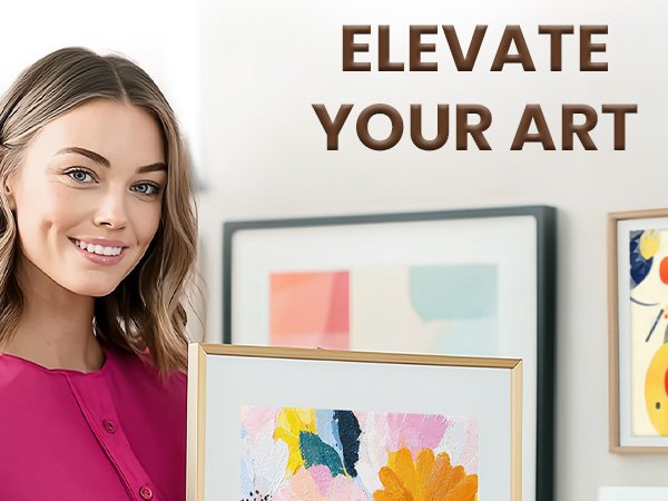 Woman holding a framed abstract painting, with other framed art on the wall behind her.