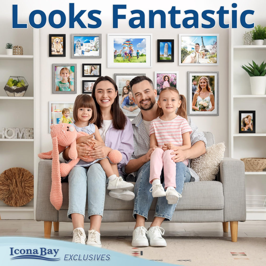 Family posing on a couch with multiple framed photos on the wall behind them, showcasing various memories.