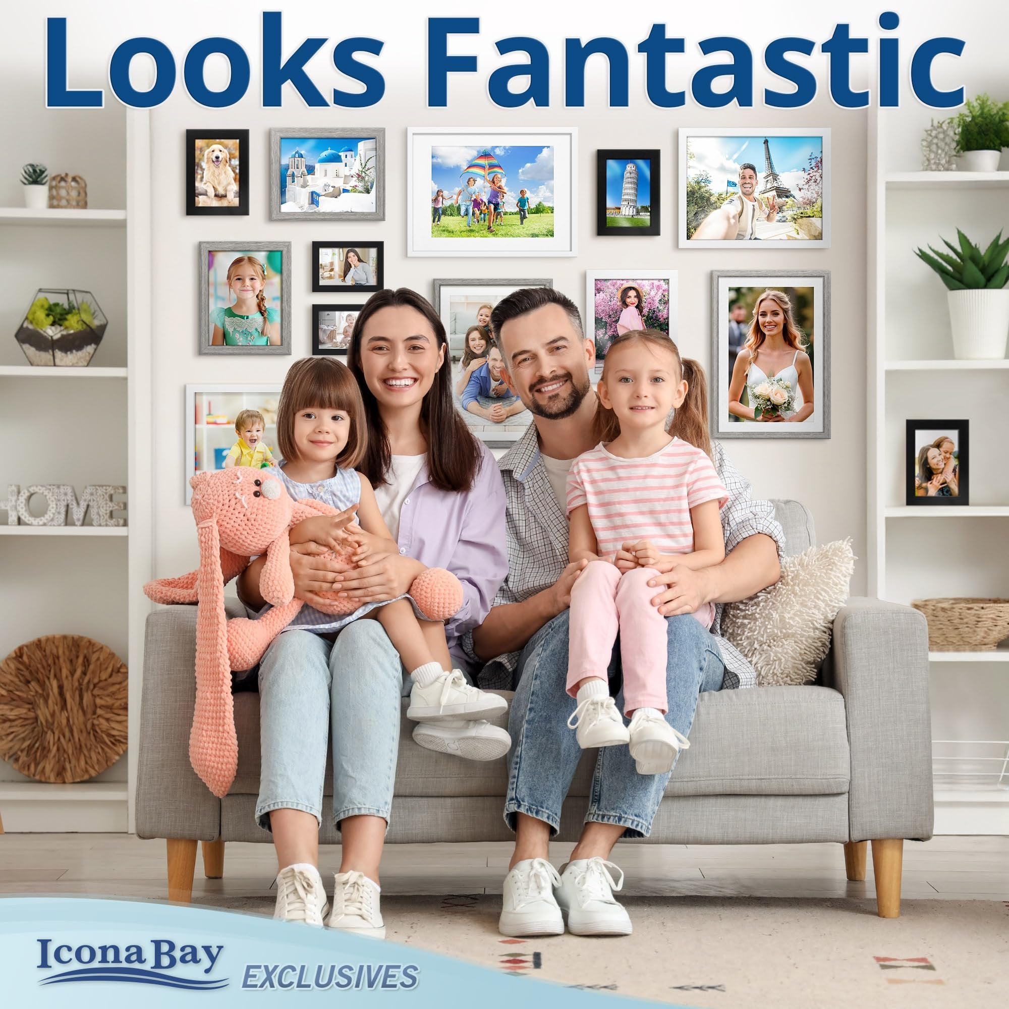 Family posing on a couch with multiple framed photos on the wall behind them, showcasing various memories.
