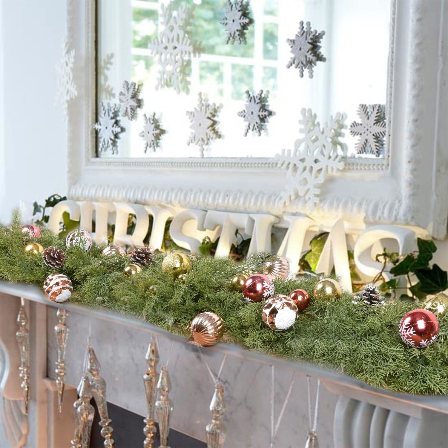 Artificial pine Christmas garland with red berries, pine cones, and ornaments on a mantlepiece.