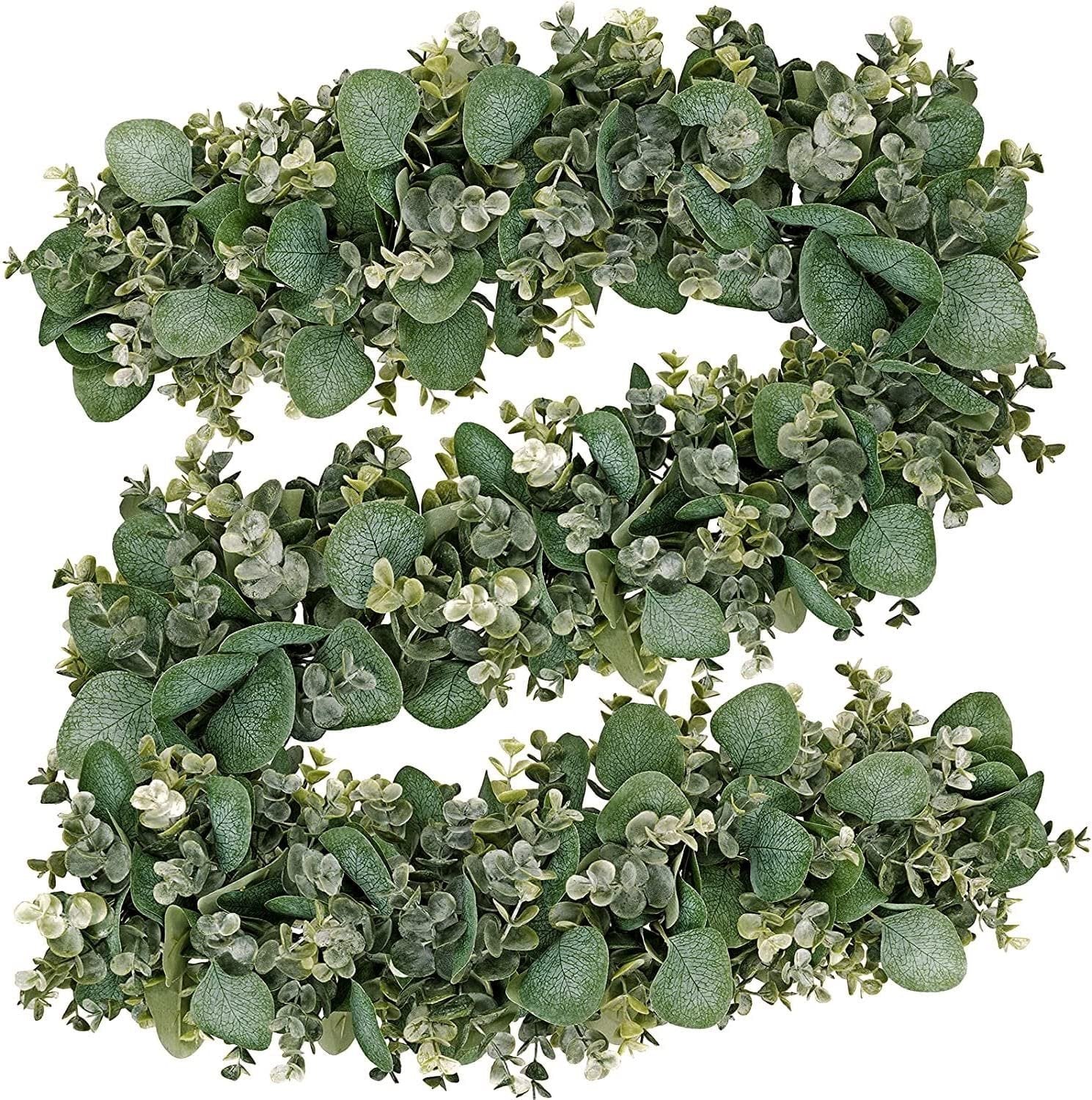 Artificial eucalyptus garland with lambs ear and magnolia leaves, arranged in a curve on a white background.