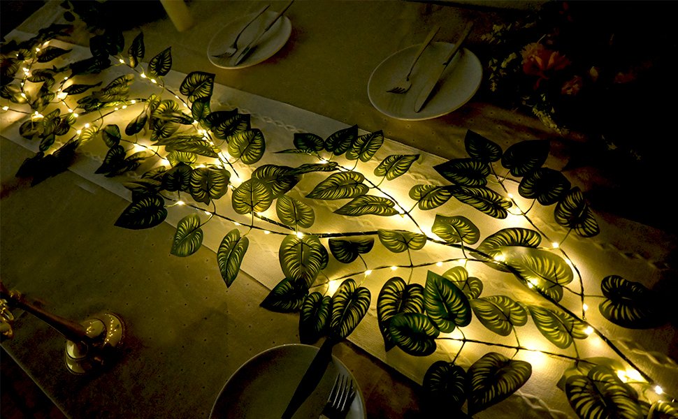 Green vine garland with 96 LED lights draped across a table setting with plates and cutlery.