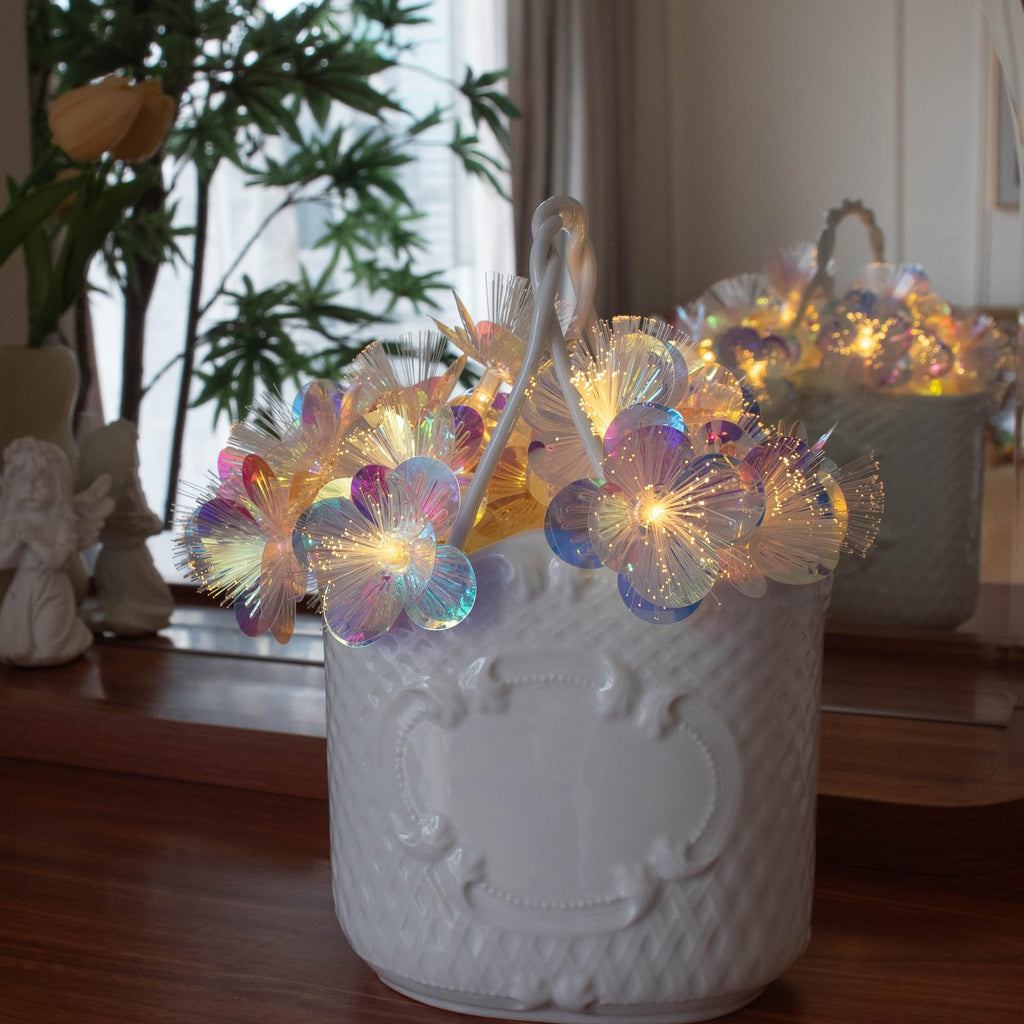Fiber optic flower string lights with warm white LEDs arranged in a white decorative basket.