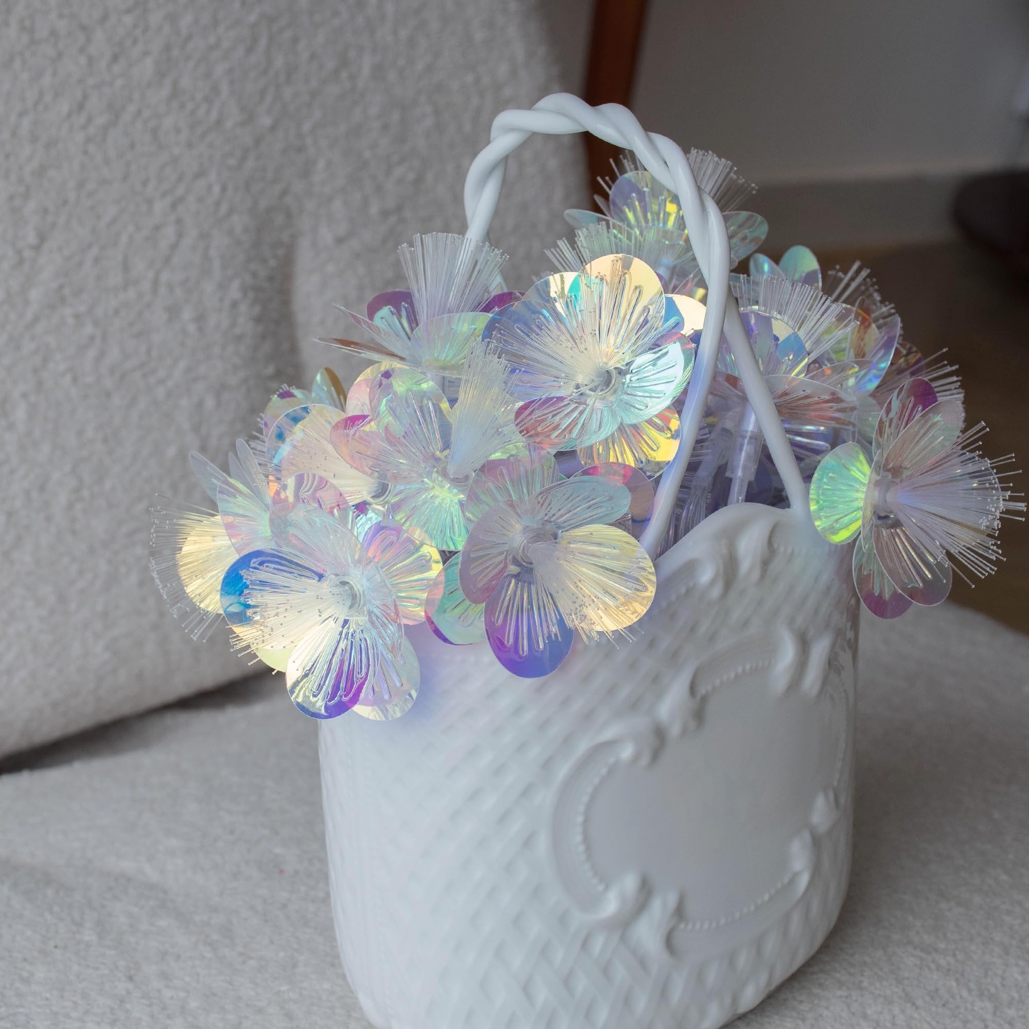 White decorative basket filled with iridescent fiber optic flower string lights