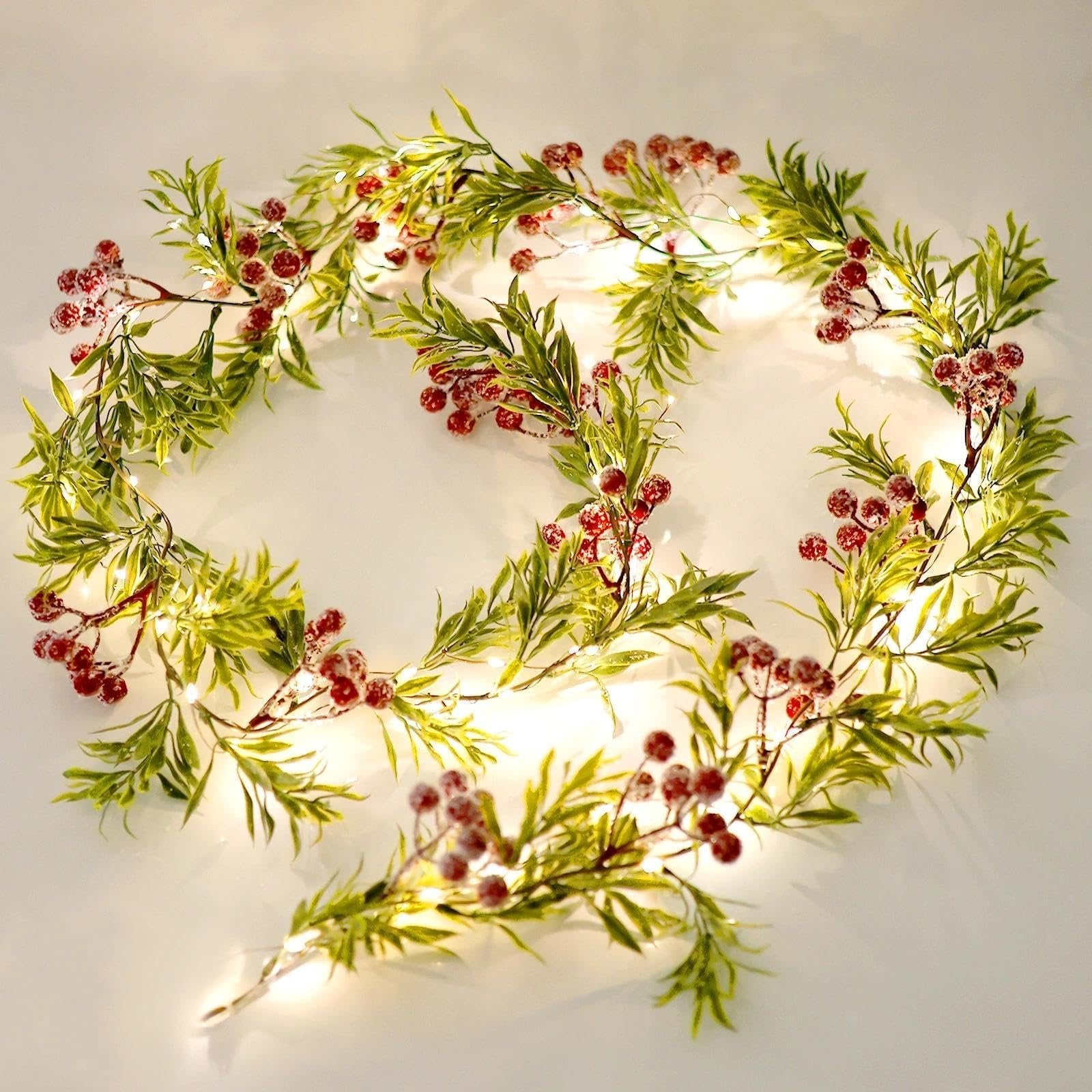 Lighted Christmas garland with green leaves and red berries, featuring 20 warm white LED lights.