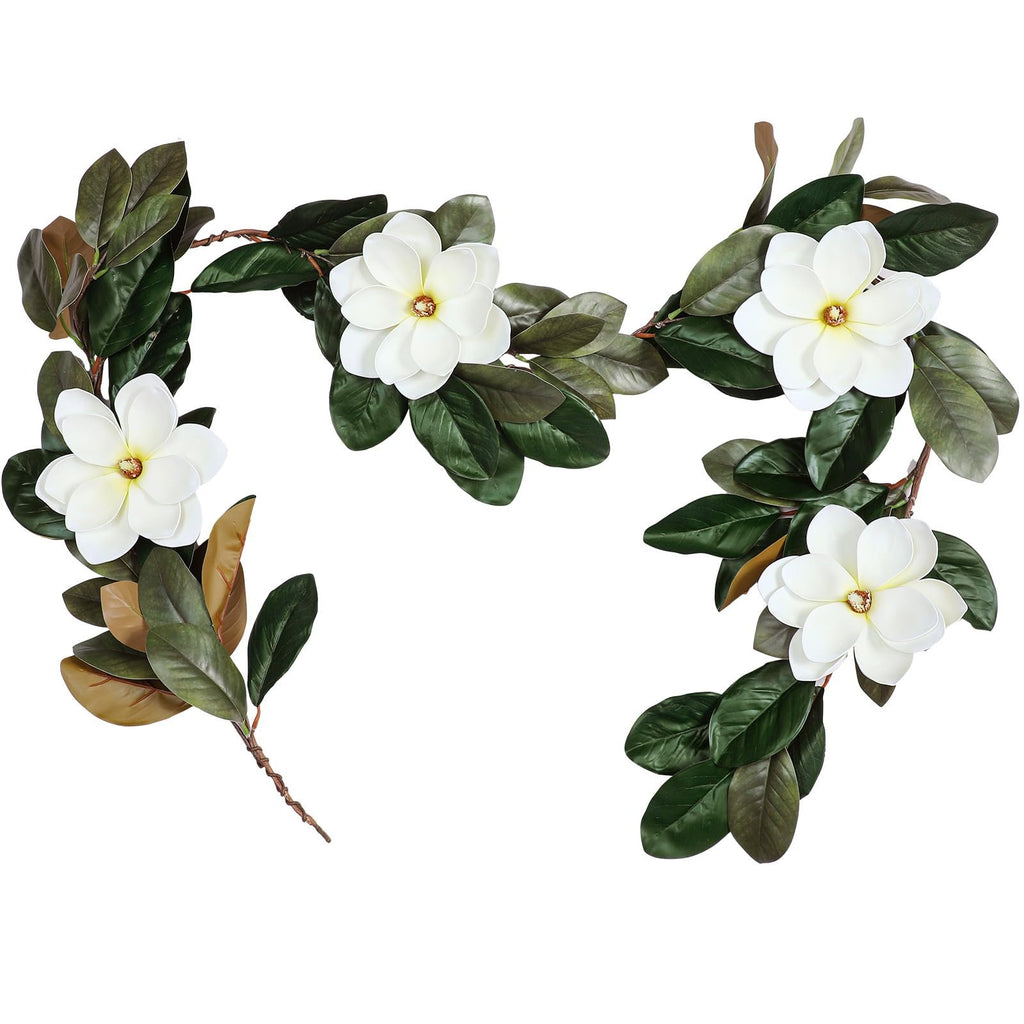 Artificial magnolia garland with white flowers and dark green leaves on a white background