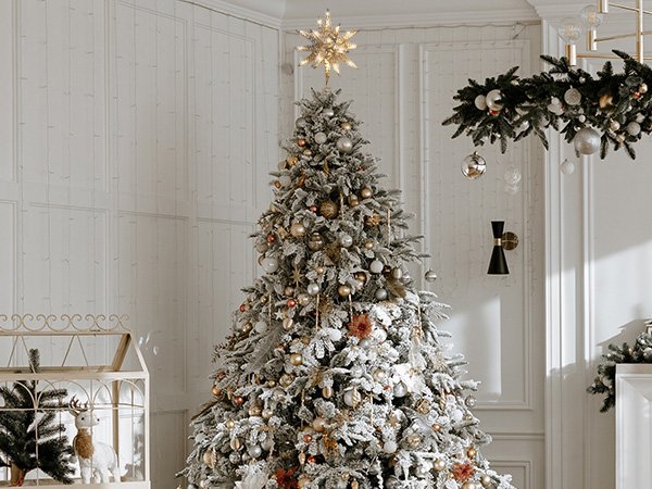 Festively decorated Christmas tree with a starburst tree topper in a cozy room setting.
