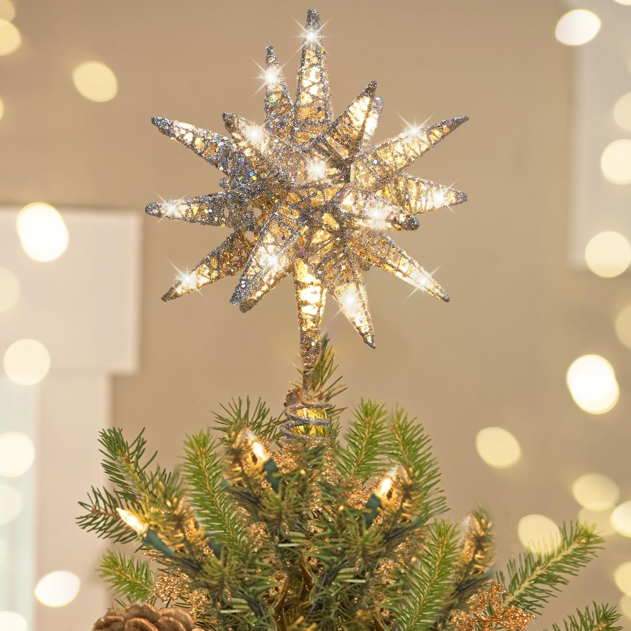 Silver starburst tree topper with lights on a Christmas tree, soft bokeh background