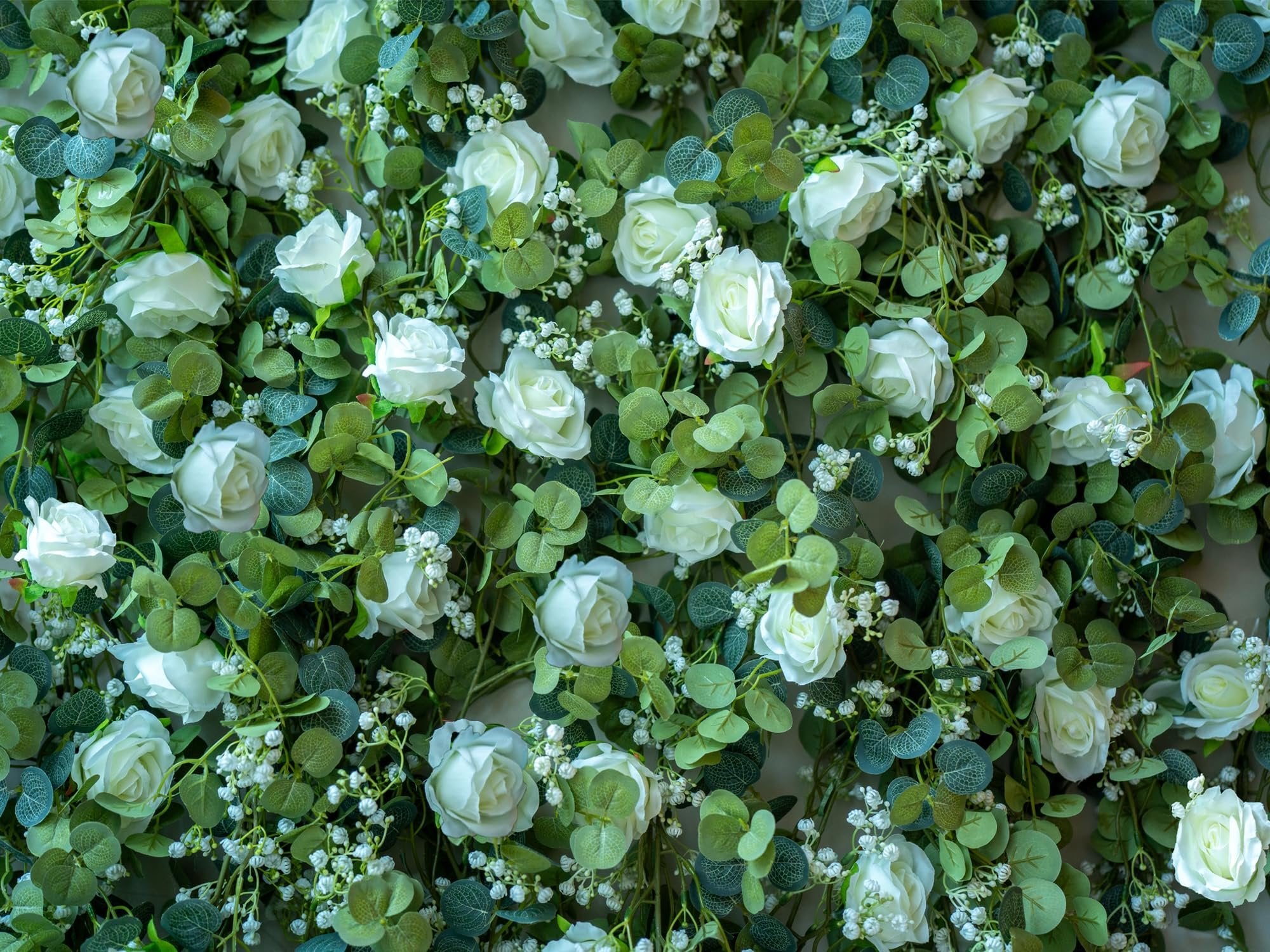 Artificial eucalyptus garland with white roses and baby's breath, close-up view