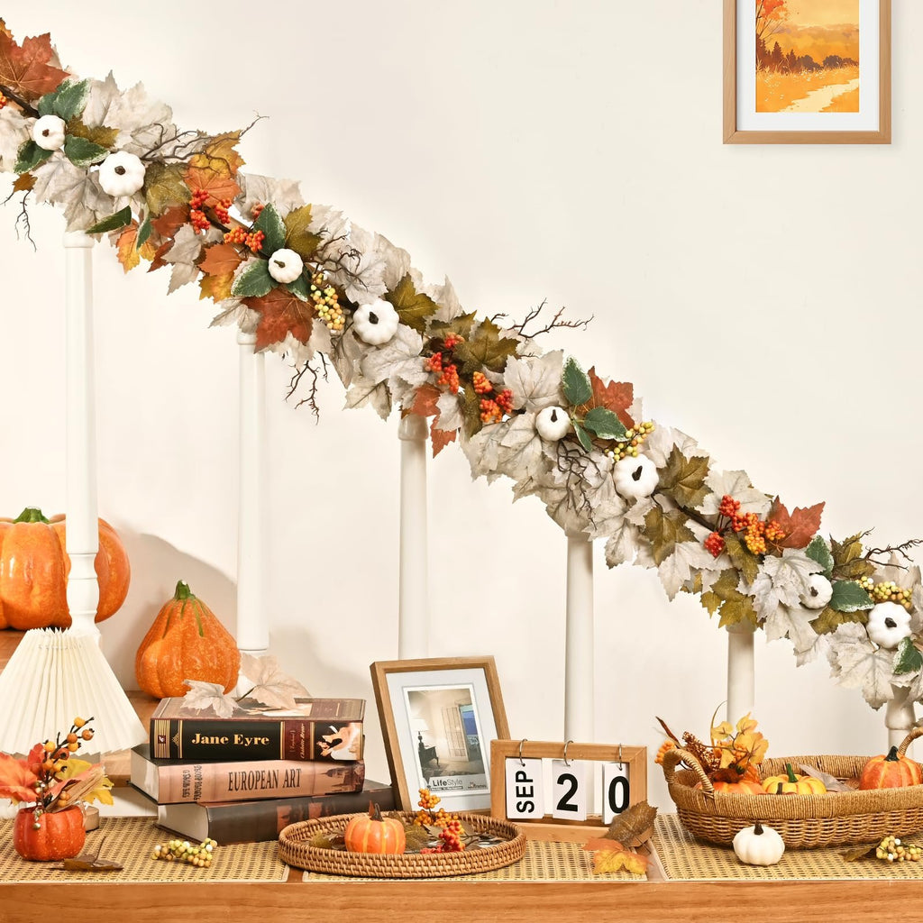 Autumn garland with maple leaves, white pumpkins, berries, and lights draped over a banister.