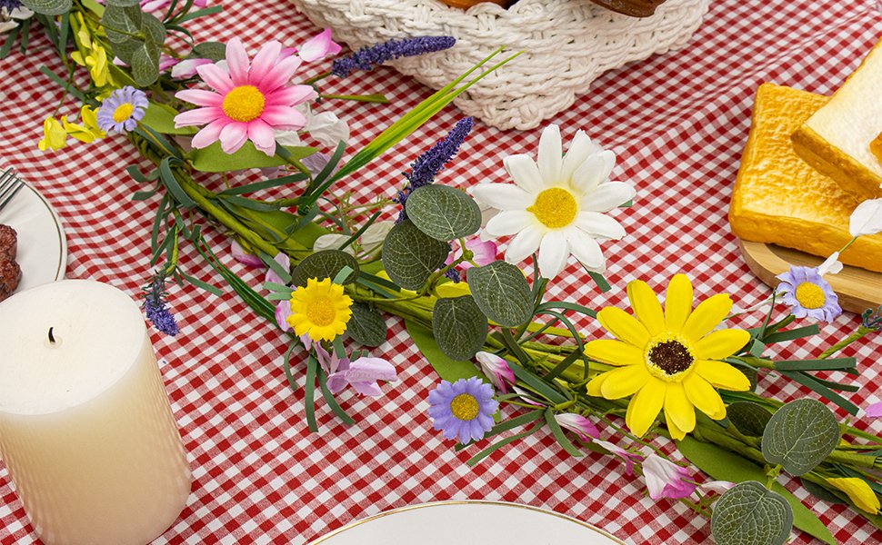 Farmhouse spring flower garland with pink, white, yellow wildflowers and daisies on a red gingham tablecloth