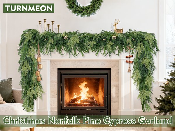 Christmas garland draped over a fireplace with a lit fire, featuring pine and cypress tips, bells, and cinnamon sticks.