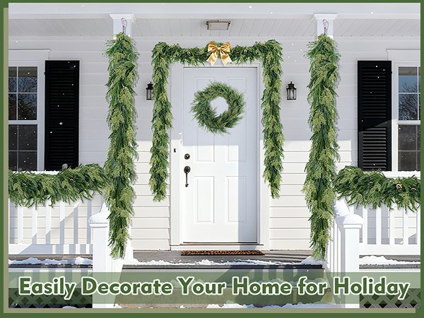 Christmas garland and wreath decorating a white house porch with snow on the ground