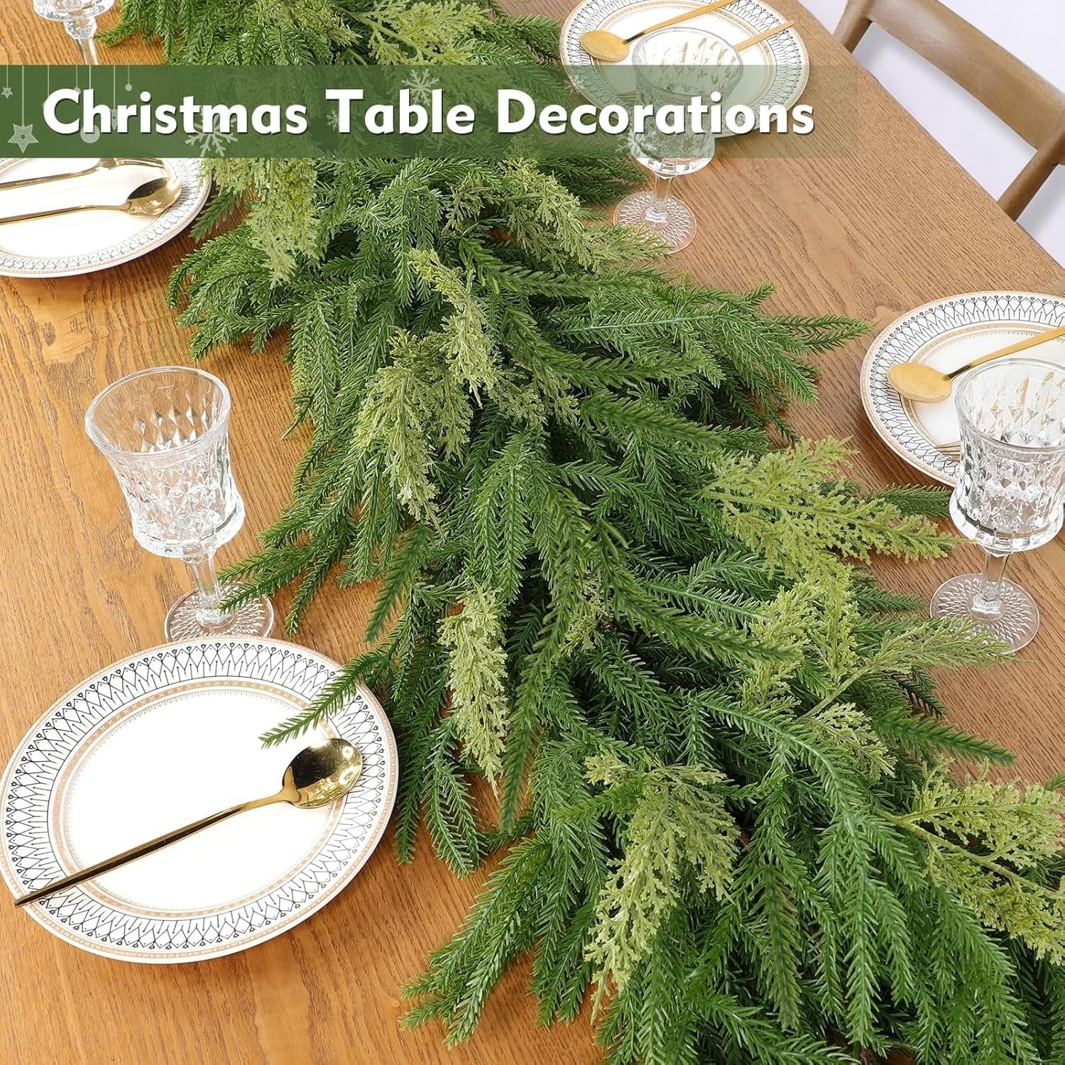 Christmas garland with realistic pine and cypress tips laid across a wooden table with place settings.