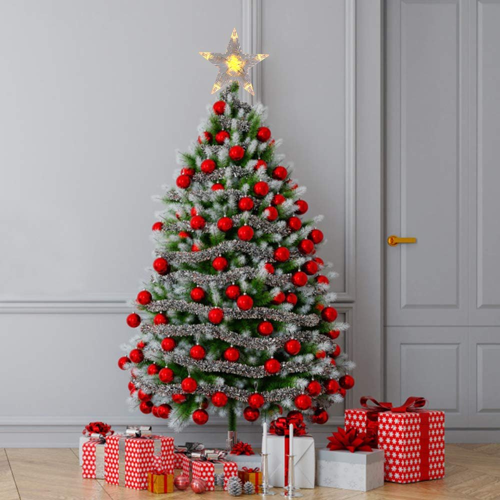 Decorated Christmas tree with a lighted star topper and presents underneath, set against a wall and door.
