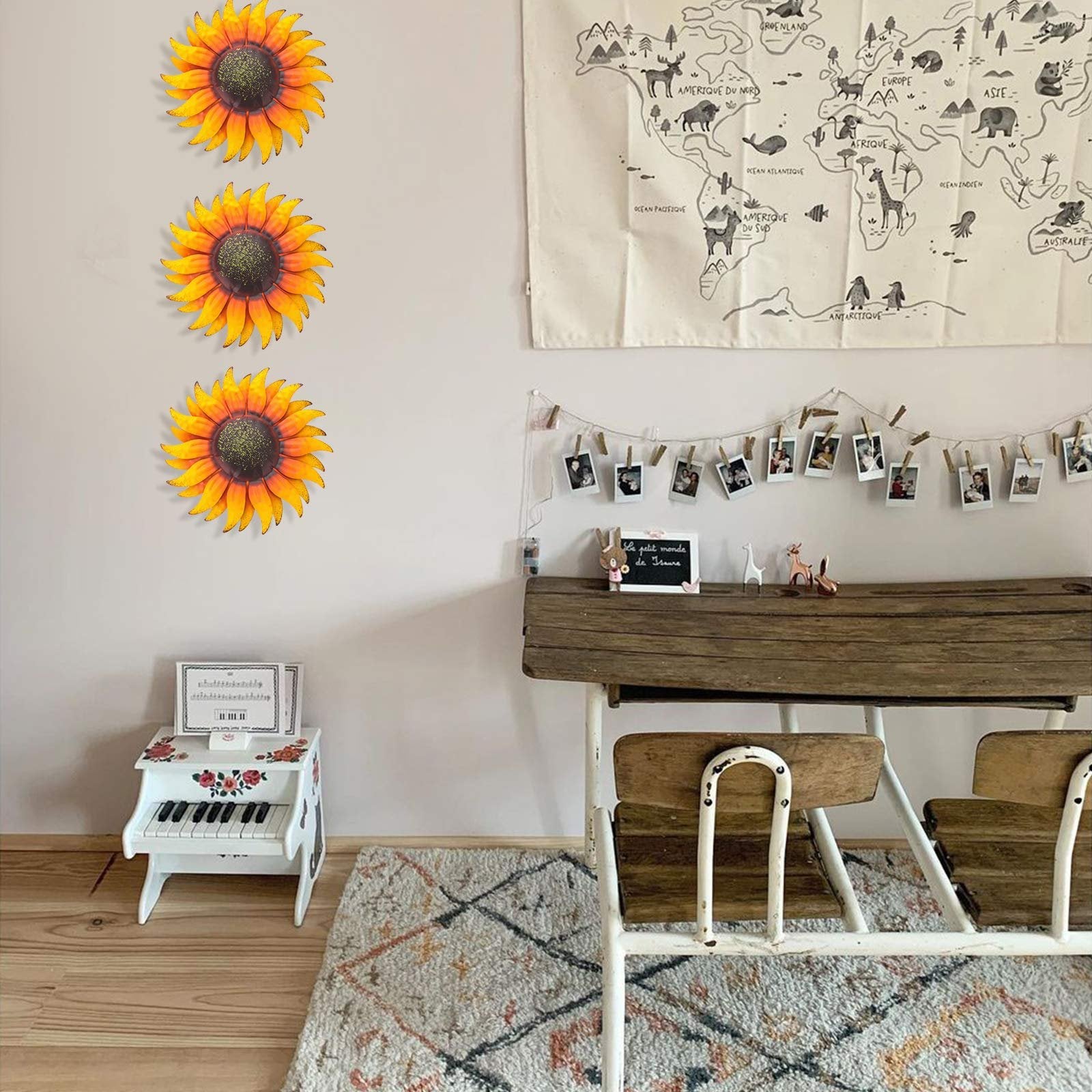 Three hand-painted metal sunflower wall art pieces arranged vertically on a light-colored wall above a desk.