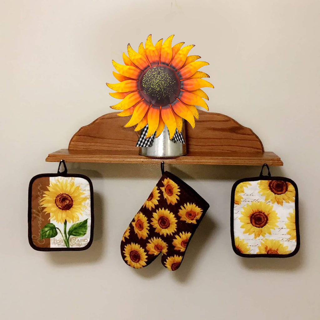 Sunflower metal wall art and matching pot holders displayed on a shelf and hooks