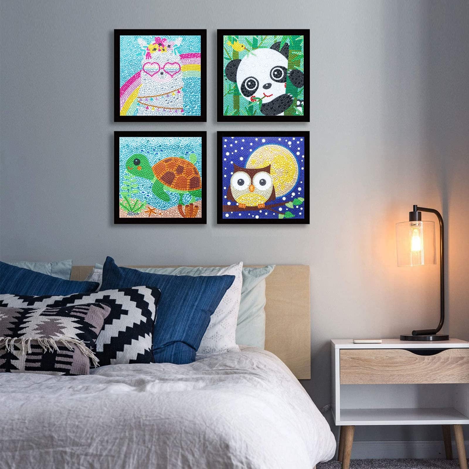 Four framed diamond painting kits of cute animals displayed on a wall above a bed.