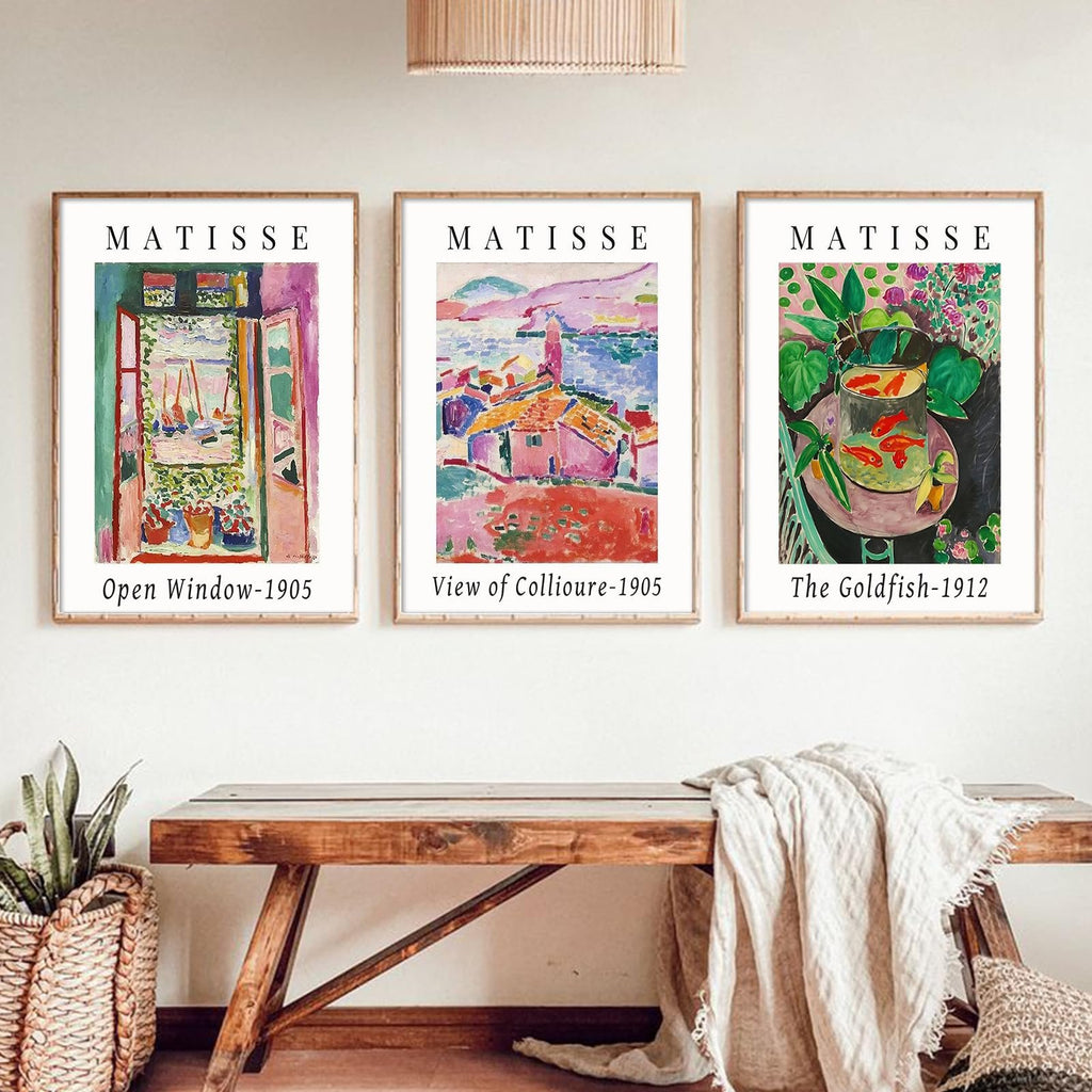 Three framed Matisse art prints displayed on a wall above a wooden bench, featuring 'Open Window-1905', 'View of Collioure-1905', and 'The Goldfish-1912'.