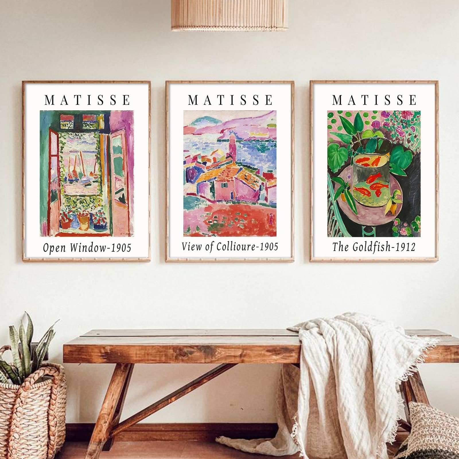 Three framed Matisse art prints displayed on a wall above a wooden bench, featuring 'Open Window-1905', 'View of Collioure-1905', and 'The Goldfish-1912'.