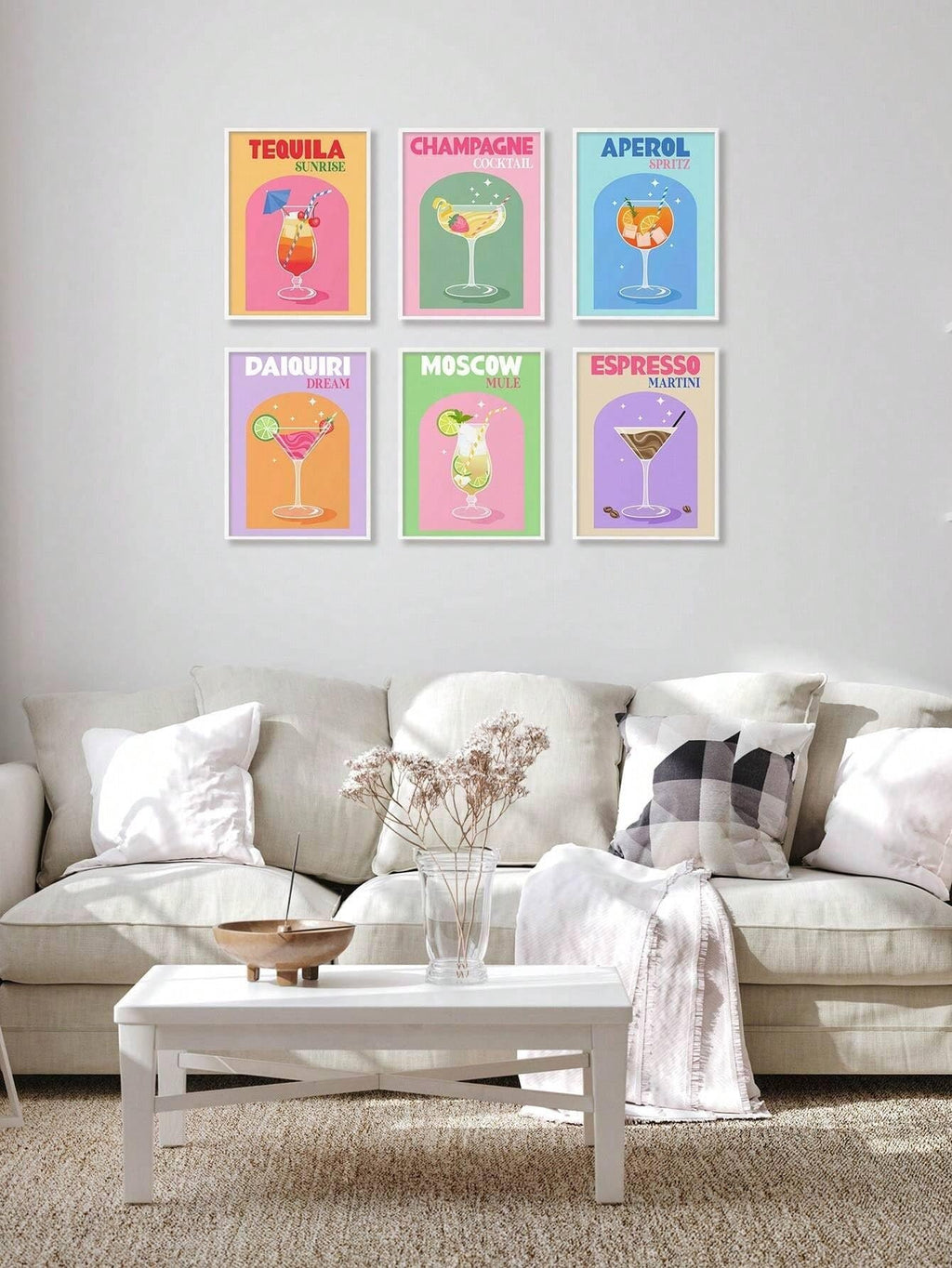 Six framed retro cocktail art prints hanging on a wall above a sofa and coffee table.