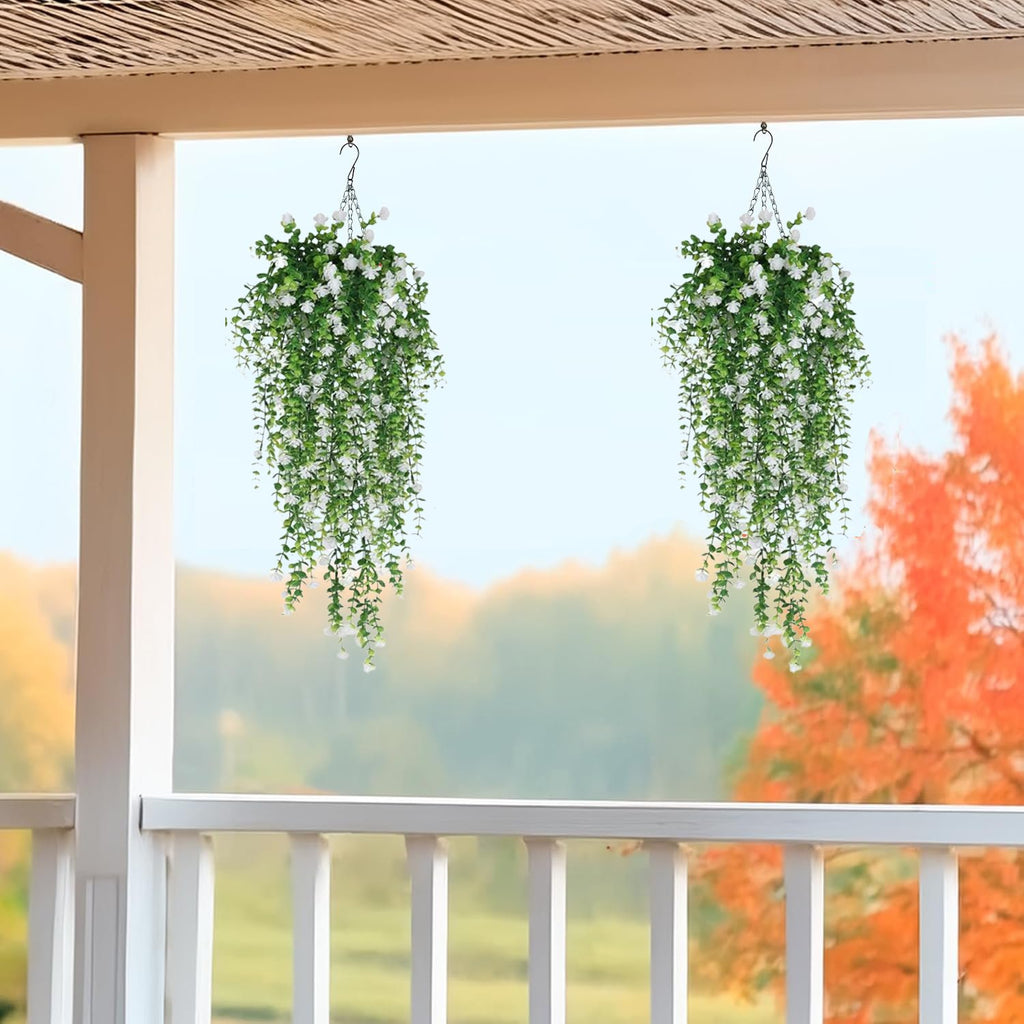 Two artificial hanging flower cascades with white blossoms and green eucalyptus vines, displayed on a porch.