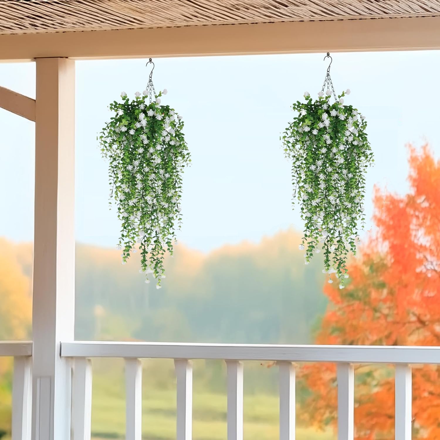 Two artificial hanging flower cascades with white blossoms and green eucalyptus vines, displayed on a porch.