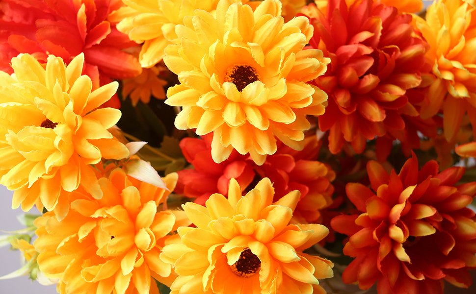 Close-up of artificial marigold silk flower bouquets in burnt orange and yellow hues.