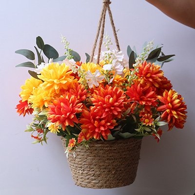 Hanging basket filled with artificial orange and yellow marigold silk flowers and greenery, suspended by rope.