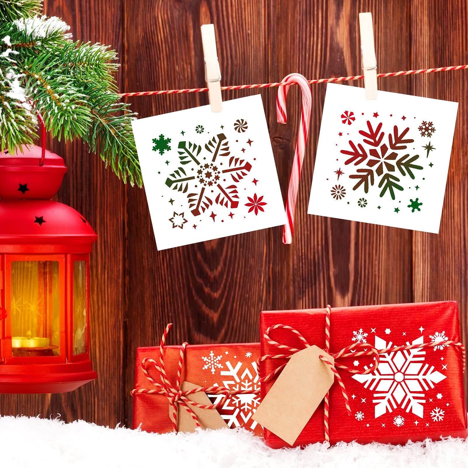 Christmas scene with snowflake stencils hanging on a line, red lantern, and wrapped gifts in snow