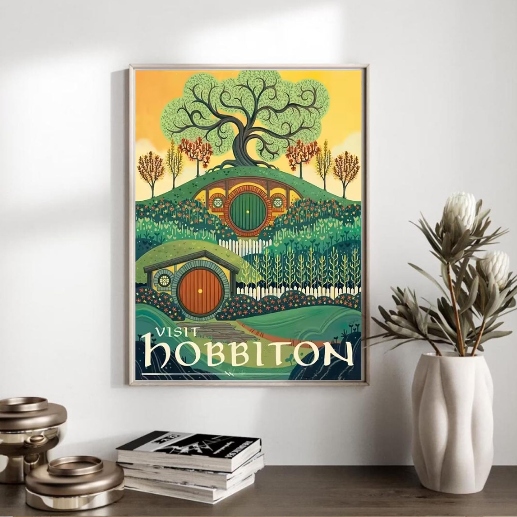 Framed artwork depicting a stylized landscape with hobbit holes and a large tree, with text 'VISIT HOBBITON' at the bottom.
