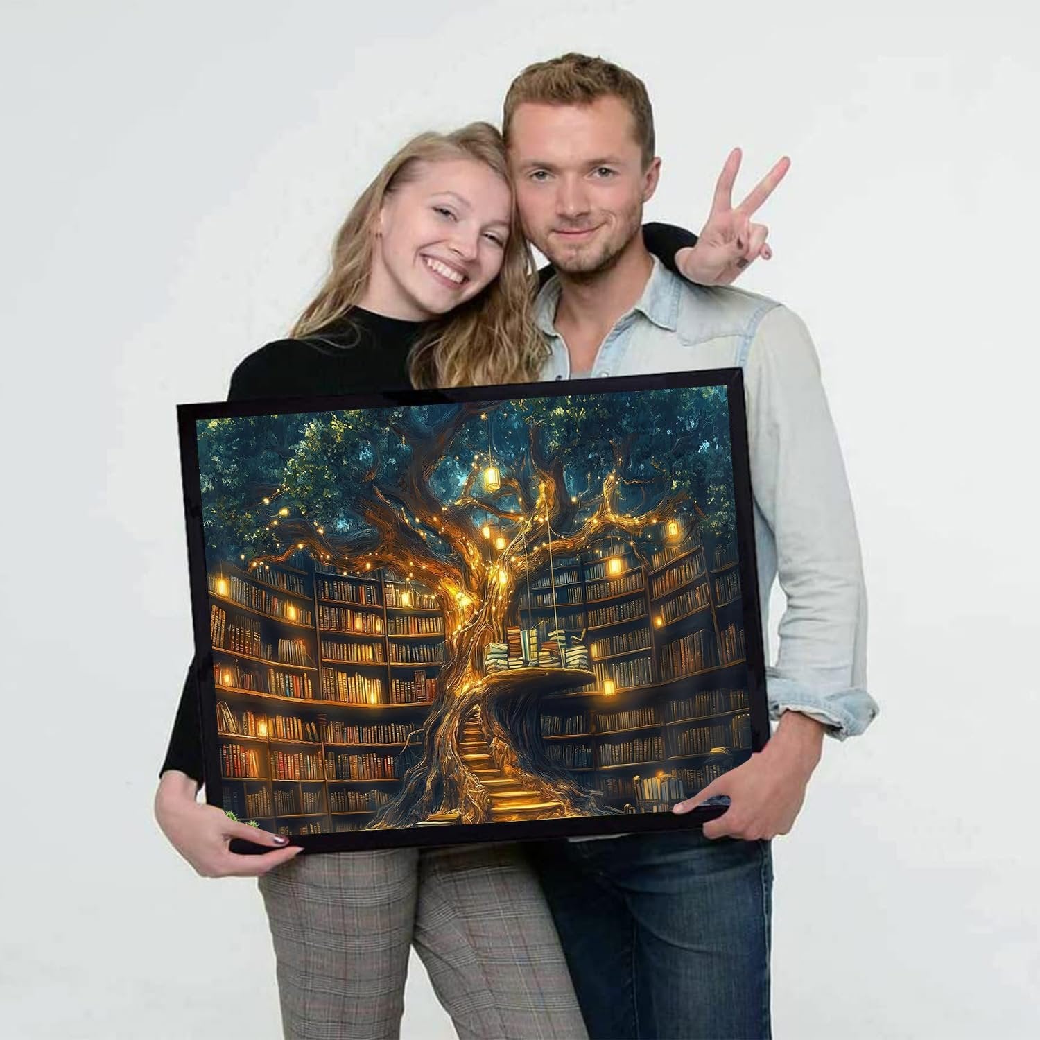 Couple holding a framed diamond painting of a treehouse library with glowing lights