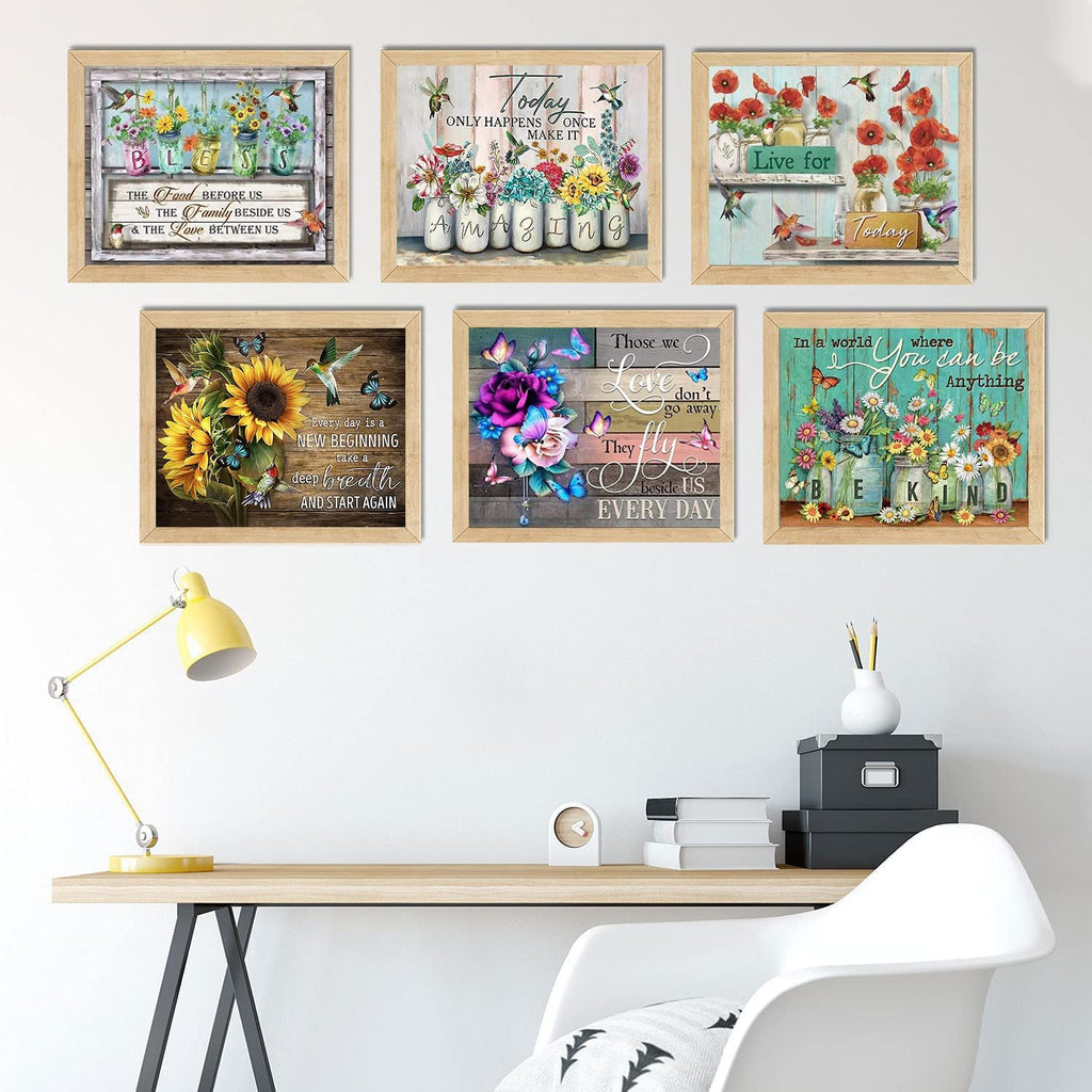 Six framed diamond painting art pieces displayed on a wall above a desk, featuring floral and inspirational quotes.