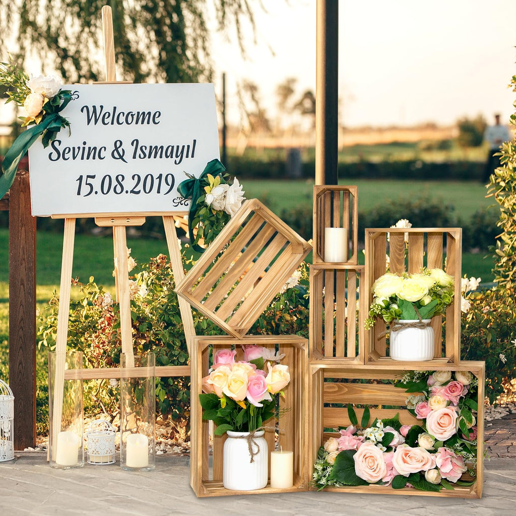 Wooden crates arranged with flowers and candles for a rustic wedding display