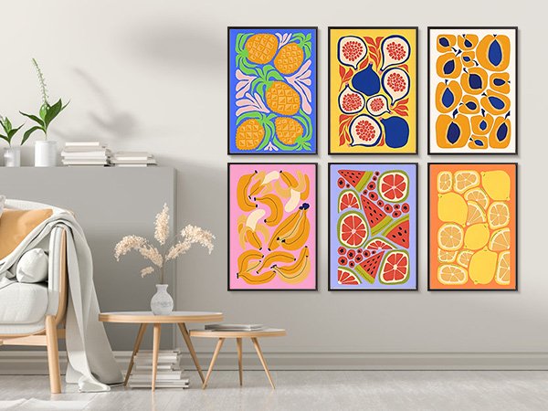 Six framed fruit art prints hanging on a wall above a sofa and coffee table.