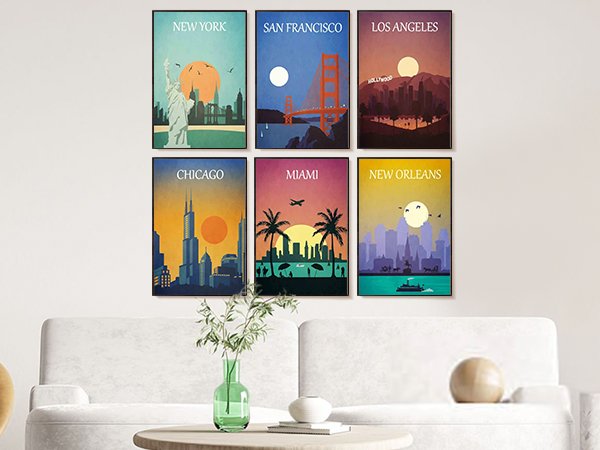 Six framed vintage travel posters of New York, San Francisco, Los Angeles, Chicago, Miami, and New Orleans displayed on a wall above a sofa.