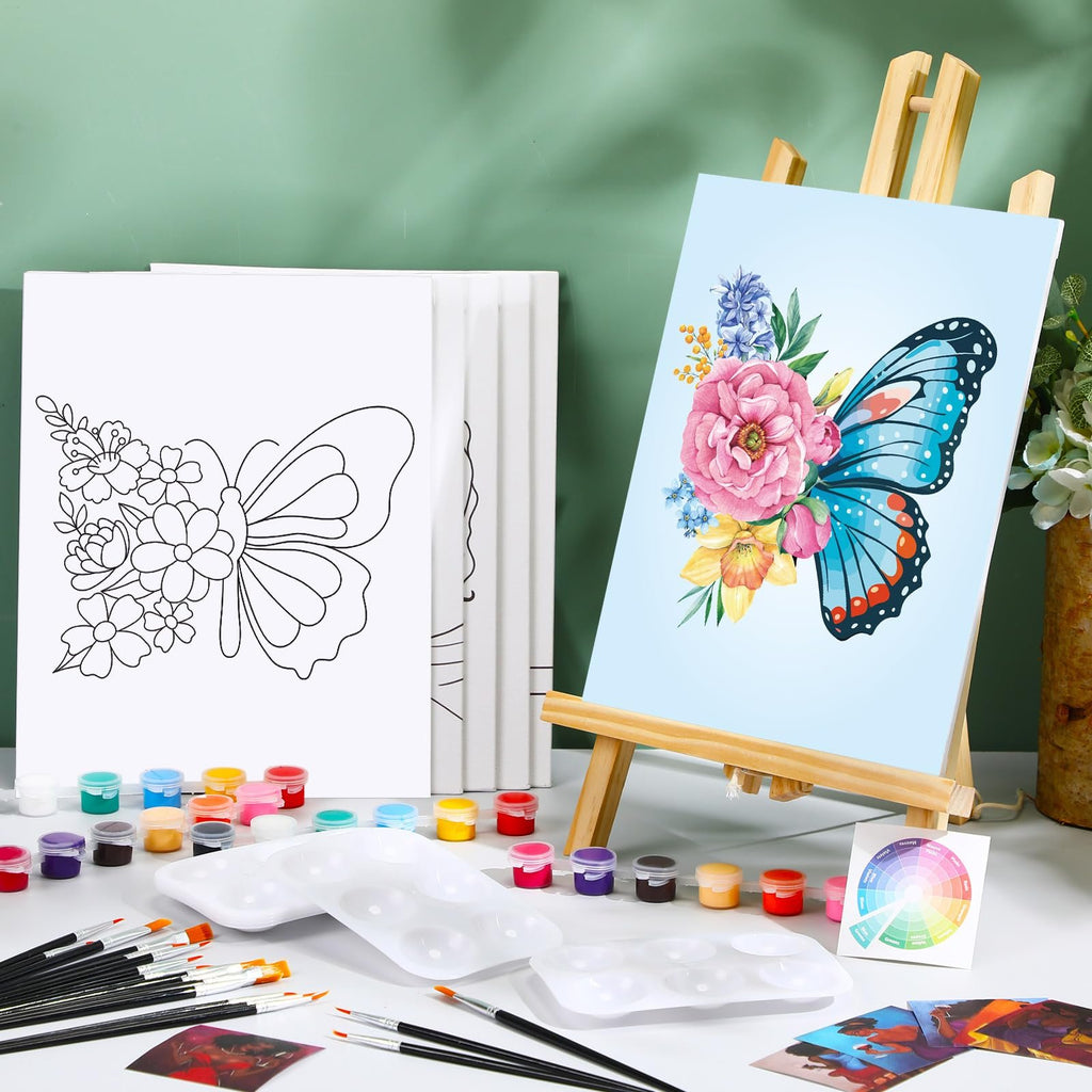 Butterfly painting kit contents including pre-drawn canvases, acrylic paints, brushes, and palettes on a white surface.