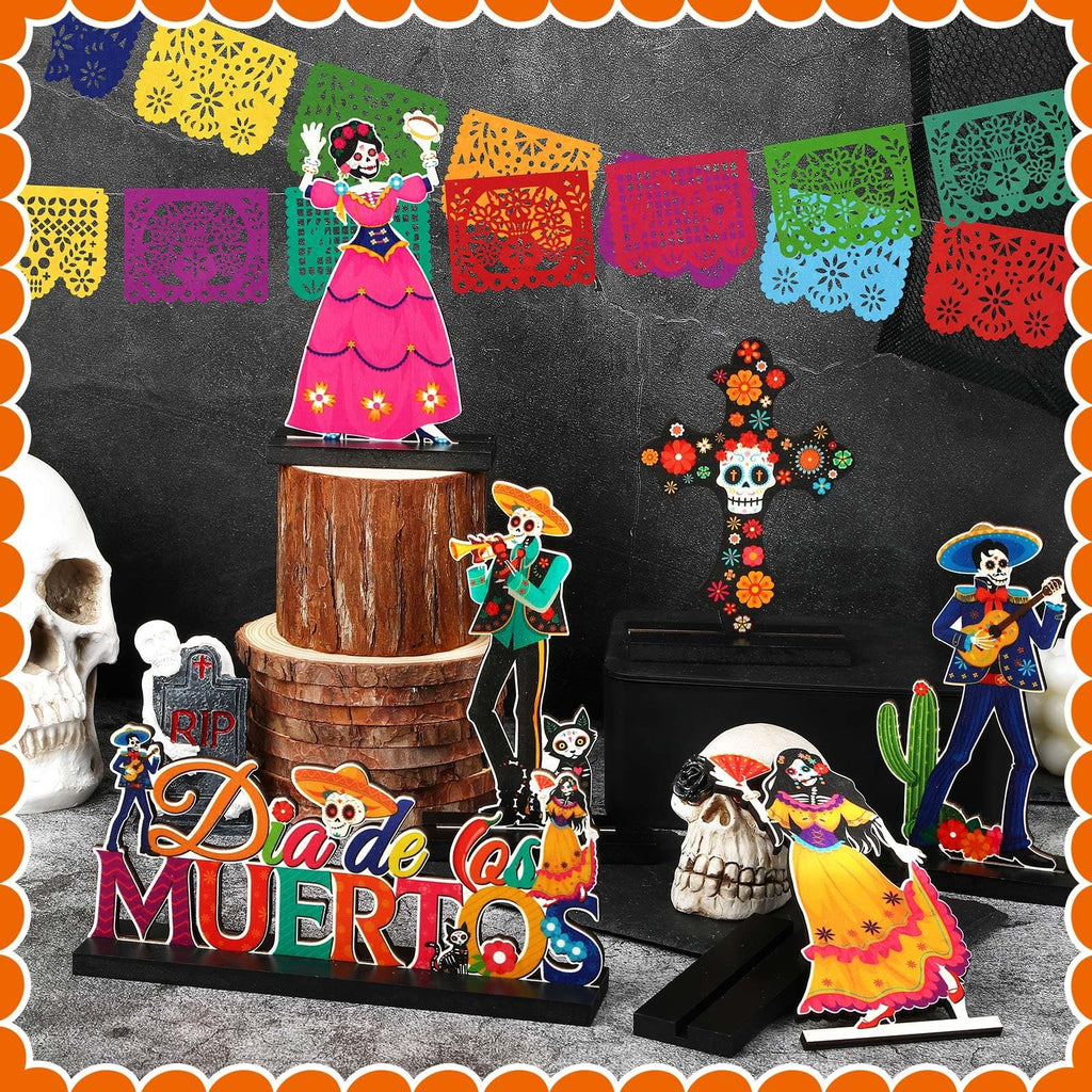 Day of the Dead centerpiece set with calavera figures, skulls, and papel picado banner.