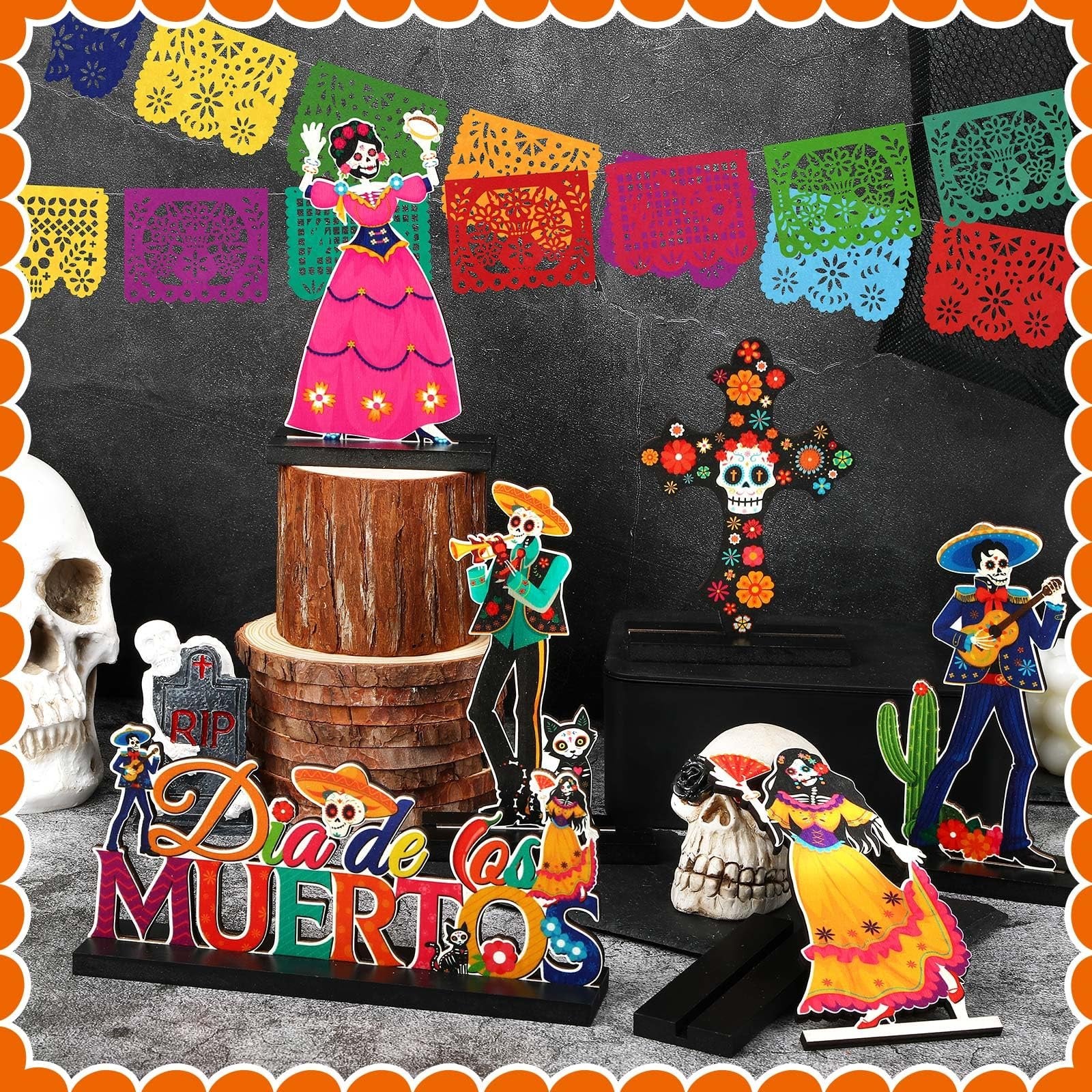 Day of the Dead centerpiece set with calavera figures, skulls, and papel picado banner.